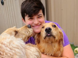 Staff hugging a golden retriever