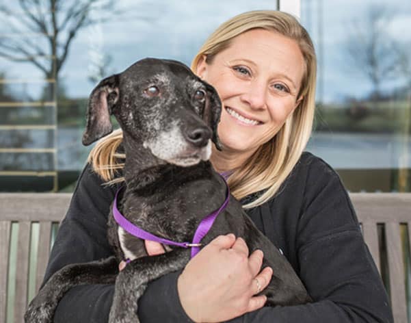 Woman holding a dog in her lap